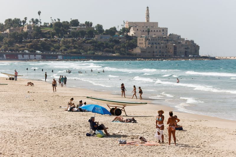 &copy; Reuters. FILE PHOTO: People hang out at the Mediterranean beach near Jaffa as coronavirus disease (COVID-19) restrictions ease in Tel Aviv, Israel October 14, 2021. REUTERS/Amir Cohen/File Photo
