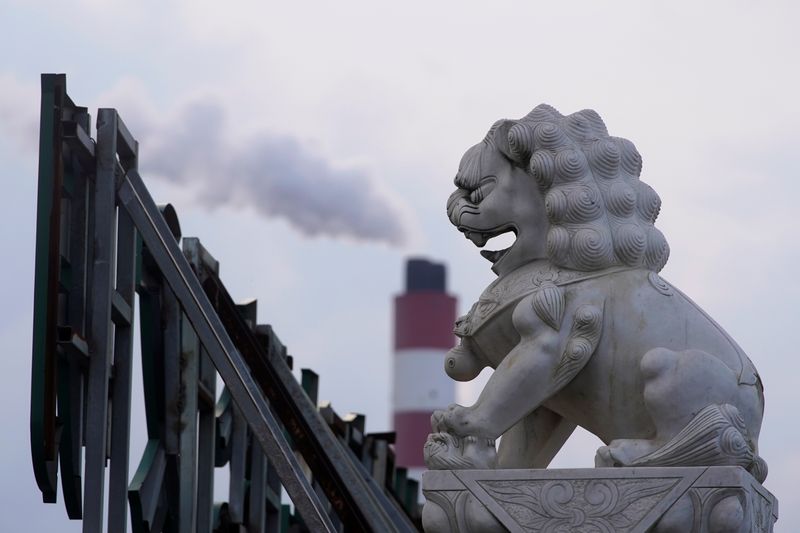 &copy; Reuters. FOTO DE ARCHIVO-La chimenea de una central eléctrica de carbón, detrás de una estatua de un león en Shanghái, China. 21 de octubre de 2021. REUTERS/Aly Song