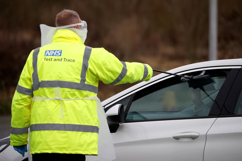 &copy; Reuters. FILE PHOTO: A member of NHS Test and Trace staff gives people a testing kit as they arrive at a mobile testing centre amid the outbreak of the coronavirus disease (COVID-19) in Southport, Britain, February 3, 2021. REUTERS/Phil Noble