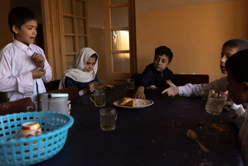 &copy; Reuters. أطفال يتناولون الشاي والخبز في الإفطار في دار للأيتام قبل الذهاب إلى المدرسة في كابول يوم 12 أكتوبر تشرين الأول 2021. تصوير: خورخي سيلفا - رويتر