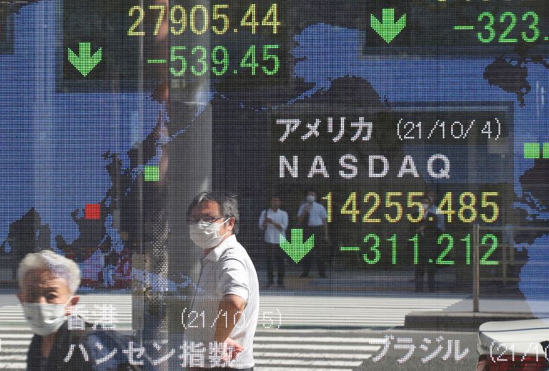 &copy; Reuters. People wearing protective masks amid the coronavirus disease (COVID-19) outbreak are reflected on an electronic board displaying Japan's Nikkei and U.S. Nasdaq index outside a brokerage in Tokyo, Japan, October 5, 2021. REUTERS/Kim Kyung-Hoon
