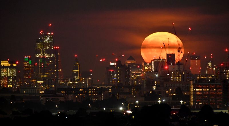 &copy; Reuters. FILE PHOTO: The full moon is seen rising behind skyscrapers at Canary Wharf and the London skyline, London, Britain, September 14, 2019. Picture taken on September 14, 2019. REUTERS/Toby Melville/File Photo
