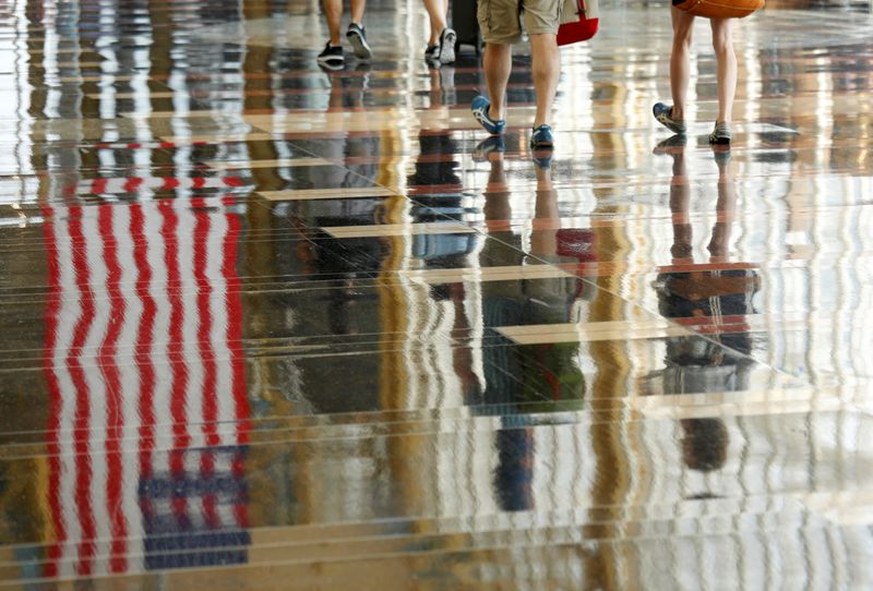 &copy; Reuters. FILE PHOTO: A U.S. flag is reflected on the floor as passengers make their way through Reagan National Airport in Washington, U.S., July 1, 2016. REUTERS/Kevin Lamarque/File Photo
