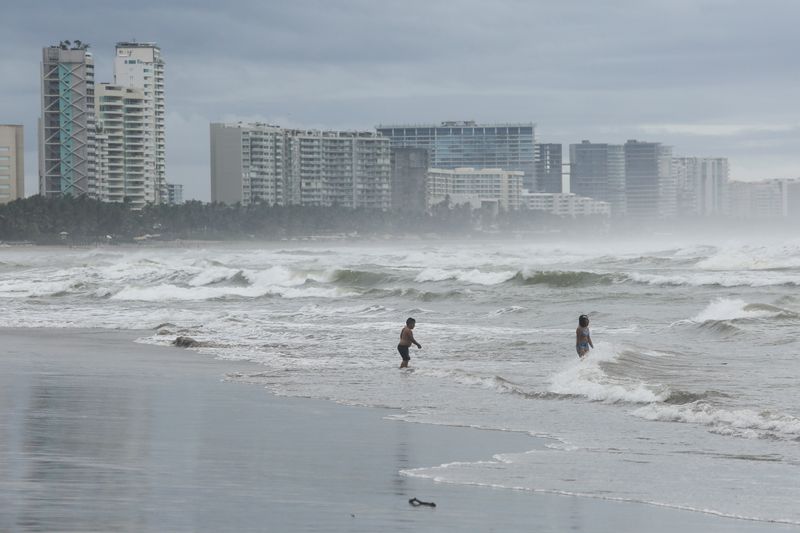 &copy; Reuters. People are pictured on a beach as Hurricane Rick edges closer to Mexican coast north of Acapulco, Mexico October 24, 2021. REUTERS/Javier Verdin