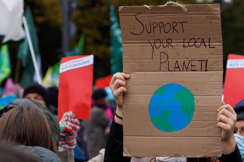 &copy; Reuters. FILE PHOTO: A demonstrator holds a sign during the Global Climate Strike of the movement Fridays for Future in Berlin, Germany, October 22, 2021. REUTERS/Michele Tantussi