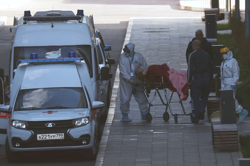 © Reuters. مسعفون ينقلون مريضا بفيروس كورونا إلى مستشفى في موسكو يوم 6 أكتوبر تشرين الأول 2021. رويترز
