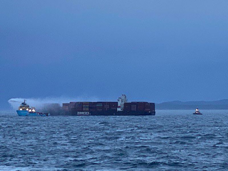 &copy; Reuters. A tugboat pours water on the container ship Zim Kingston after it caught fire off the coast of Victoria, British Columbia, Canada October 25, 2021.  Canadian Coast Guard/Handout via REUTERS