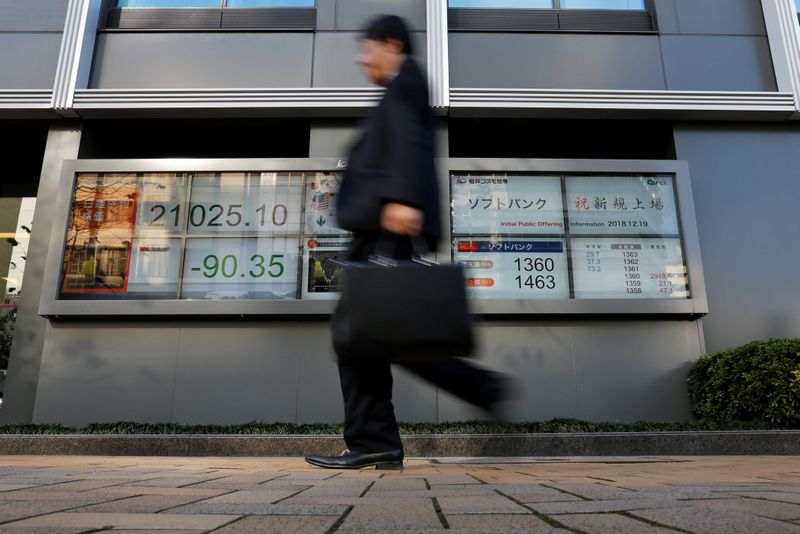 &copy; Reuters. FILE PHOTO: A man walks past in front of a stock quotation board showing the price of the SoftBank Corp. and Nikkei share average outside a brokerage in Tokyo, Japan December 19, 2018.  REUTERS/Issei Kato