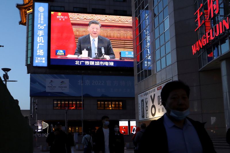 © Reuters. FILE PHOTO: A giant screen shows news footage of Chinese President Xi Jinping attending a video summit on climate change with German Chancellor Angela Merkel and French President Emmanuel Macron, at a shopping street in Beijing, China April 16, 2021. REUTERS/Florence Lo