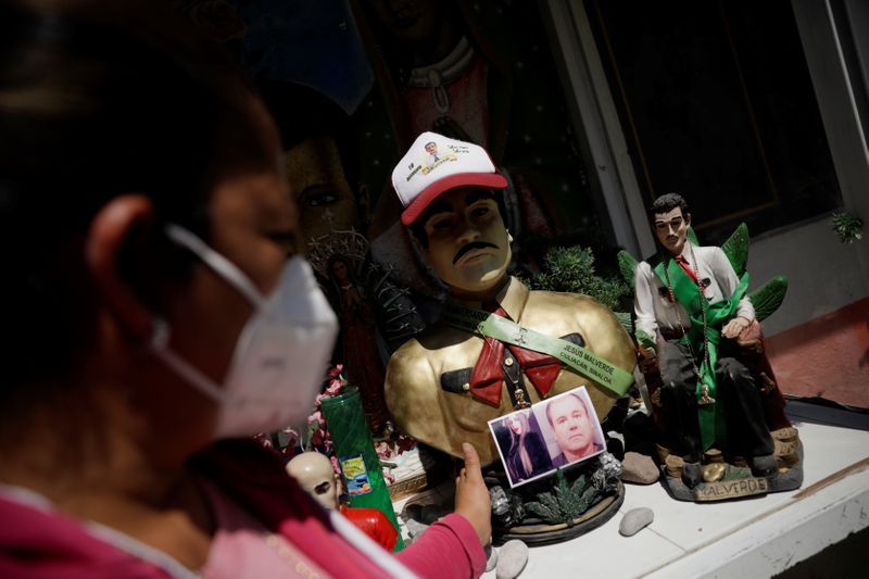 &copy; Reuters. Una persona reza en un altar decorado con fotos de  Joaquín "El Chapo" Guzmán en México 26 de febrero del 2021. REUTERS/Luis Cortes - 