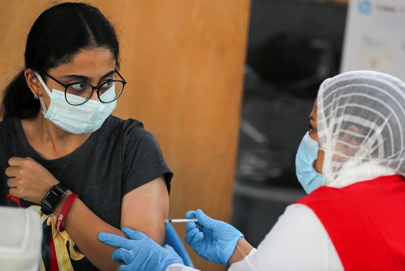 &copy; Reuters. امرأة تحصل على تطعيم ضد كوفيد-19 في القاهرة يوم 27 سبتمبر ايلول 2021. تصوير: محمد عبد الغني - رويترز. 
