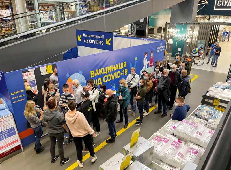 © Reuters. People wait to receive a vaccine against the coronavirus disease (COVID-19) at a vaccination centre opened in a construction supplies hypermarket in Kyiv, Ukraine October 23, 2021.  REUTERS/Gleb Garanich
