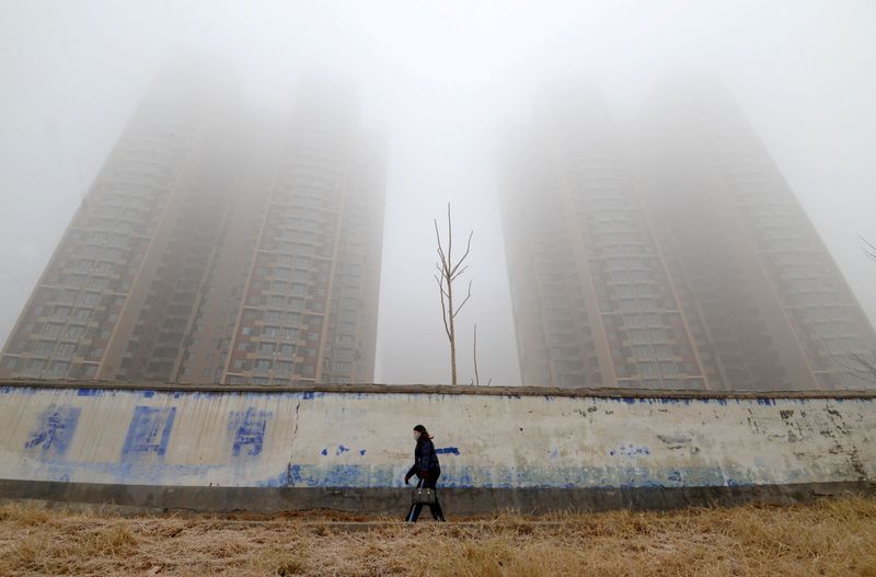 &copy; Reuters. Mulher usando máscara caminha perto de prédios em meio à poluição em Hebei, na China
12/01/2019 REUTERS/Stringer 