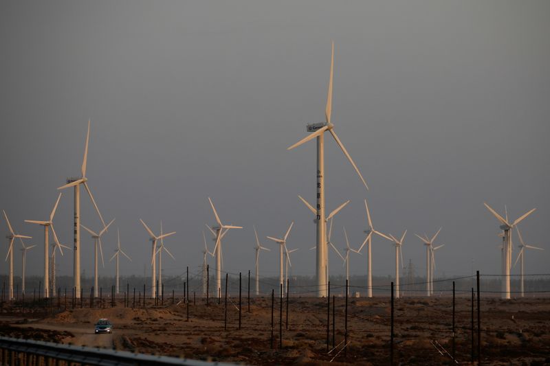 &copy; Reuters. FILE PHOTO: A car drives near wind turbines on a power station near Yumen, Gansu province, China September 29, 2020. Picture taken September 29, 2020. REUTERS/Carlos Garcia Rawlins/File Photo/File Photo