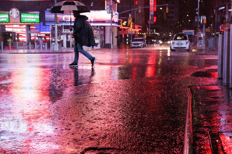 &copy; Reuters. A person walks through Times Square during a nor'easter in New York, U.S. October 26, 2021. REUTERS/Caitlin Ochs