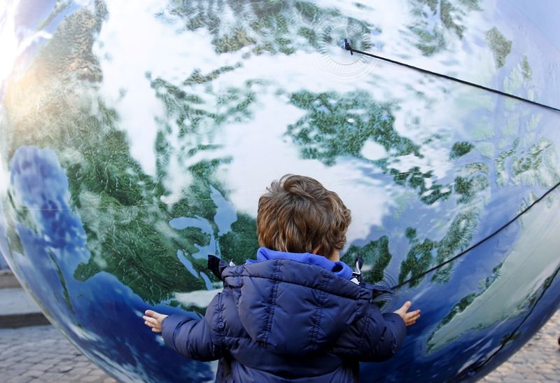 &copy; Reuters. FILE PHOTO: A child embraces a globe shaped balloon during a rally held ahead of the start of the 2015 Paris World Climate Change Conference, known as the COP21 summit, in Rome, Italy , November 29, 2015. REUTERS/Alessandro Bianchi