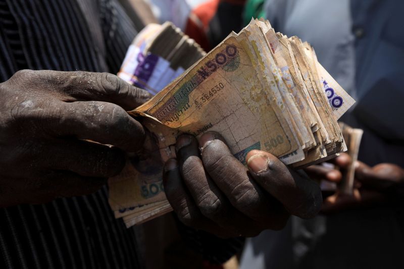 &copy; Reuters. FILE PHOTO: A man carries Nigerian naira banknotes at a livestock market in Abuja, Nigeria July 29, 2020. REUTERS/Afolabi Sotunde   