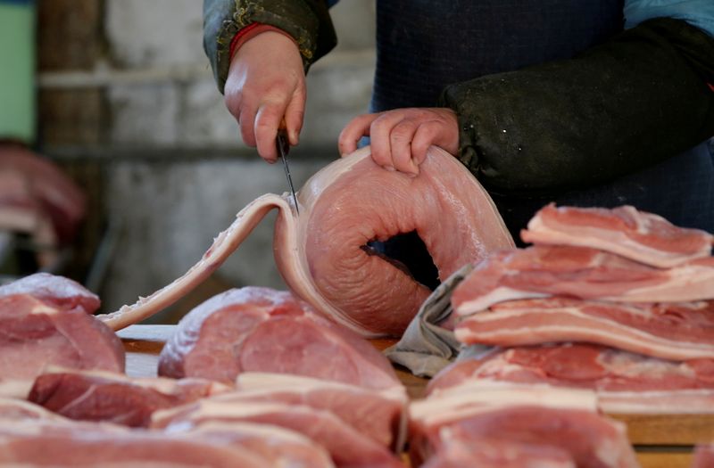 &copy; Reuters. FILE PHOTO: A butcher cuts a piece of pork at a market in Beijing, China, March 25, 2016. REUTERS/Jason Lee