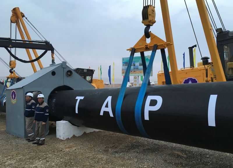 &copy; Reuters. FILE PHOTO: Workers stand near a gas pipe during the launching ceremony of construction work of the TAPI project on the Afghan section of a natural gas pipeline that will link Turkmenistan through Afghanistan to Pakistan and India, near the town of Serhet