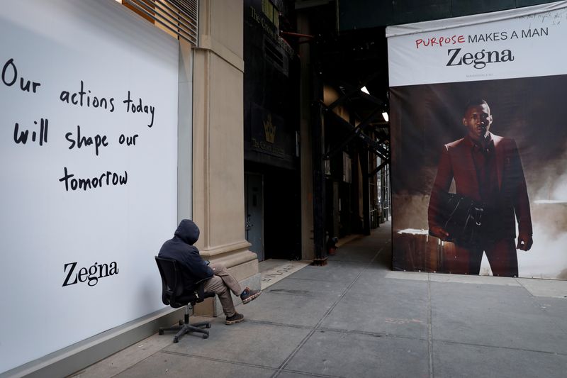 &copy; Reuters. Un uomo seduto sul marciapiede accanto a un punto vendita di Ermenegildo Zegna a Manhattan, New York, 11 maggio 2020. REUTERS/Mike Segar