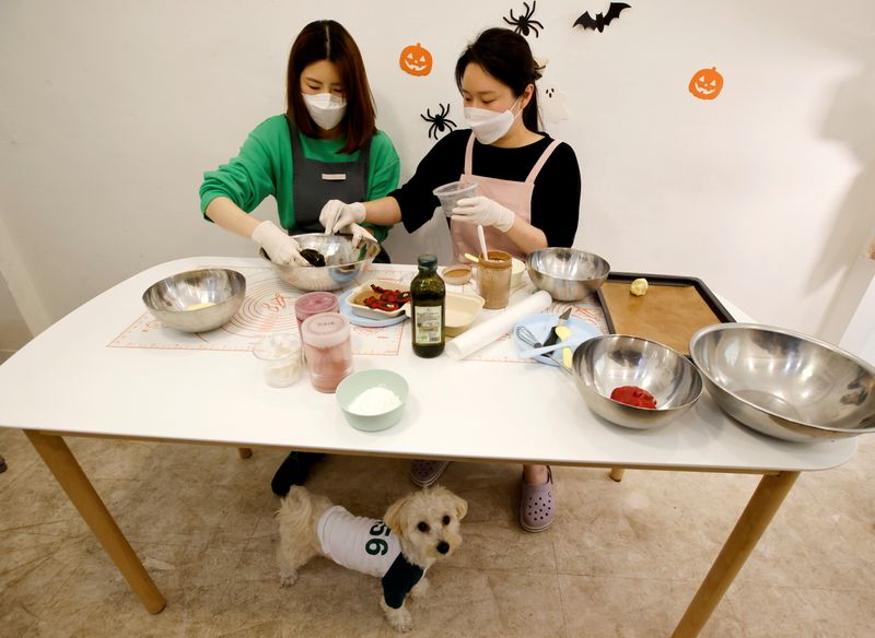 &copy; Reuters. Lee Jin-sun, propietaria de la tienda, y Hwang Hye-won, una de sus estudiantes, preparan galletas para perros inspiradas en la serie de Netflix "El juego del calamar" en una tienda para mascotas en Seúl, Corea del Sur. 26 de octubre, 2021. REUTERS/Heo Ra