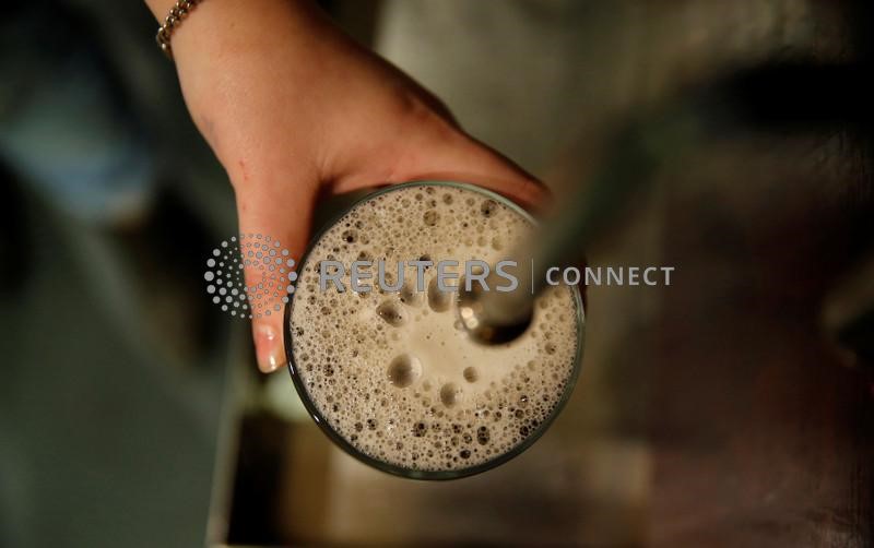 &copy; Reuters. FILE PHOTO: A bartender pulls a pint of bitter at the Flying Horse pub in London November 19, 2014. REUTERS/Suzanne Plunkett/File Photo