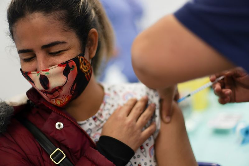 &copy; Reuters. FILE PHOTO: A woman receives a dose of Pfizer/BioNTech coronavirus disease (COVID-19) vaccine during a vaccination campaign inside the University of Santiago, Chile June 30, 2021. REUTERS/Ivan Alvarado