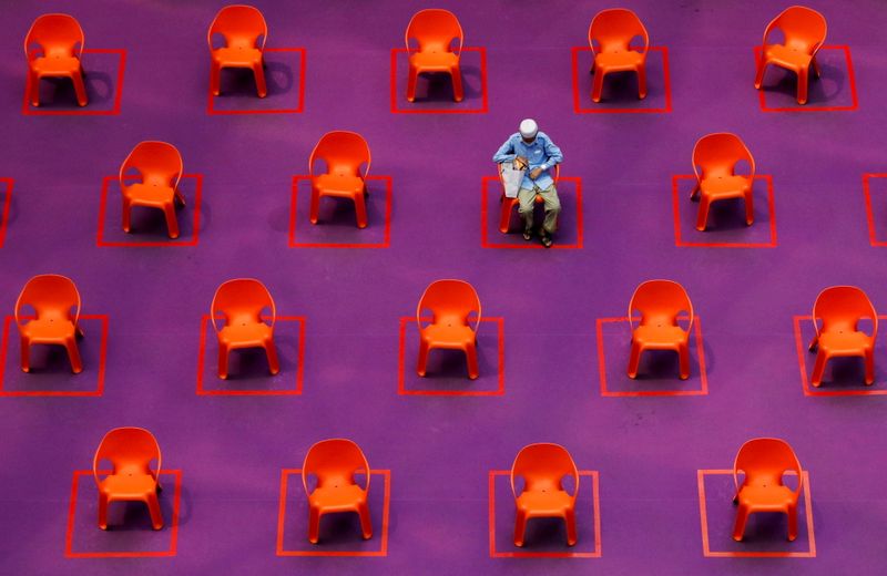 &copy; Reuters. FILE PHOTO: A man sits amongst empty seats at a free movie screening as restrictions on social gathering are tightened due to the surge of cases in the coronavirus disease (COVID-19) outbreak, in Singapore, September 29, 2021. REUTERS/Edgar Su