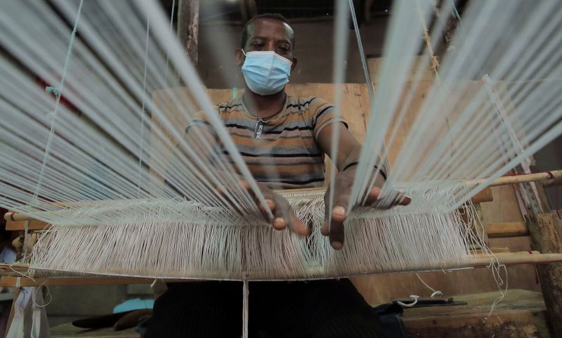 &copy; Reuters. FILE PHOTO: Tadele Abate, 37, weaves a fabric at the Sammy Ethiopia hand made garments, hand-woven textiles and basketry factory in Addis Ababa, Ethiopia, October 14, 2021. REUTERS/Tiksa Negeri