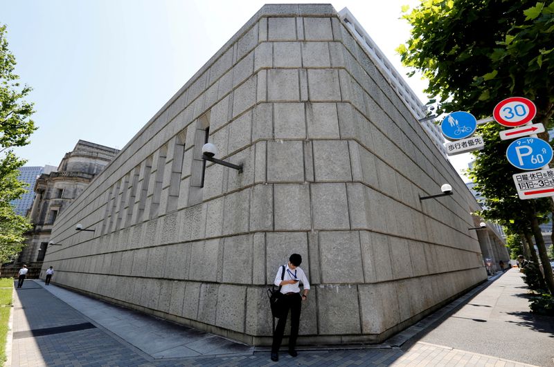&copy; Reuters. Un hombre mira su teléfono frente al edificio del Banco de Japón, Tokio, Japón, 16 junio 2017.   
REUTERS/Toru Hanai