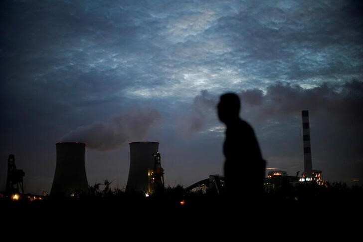 © Reuters. Homem passa em frente à usina de carvão em Xangai, China
14/10/2021 REUTERS/Aly Song