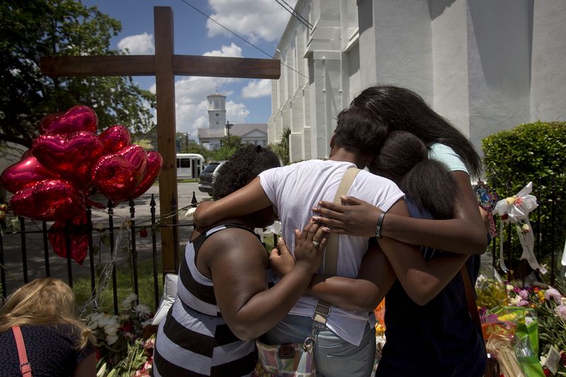 © Reuters. FILE PHOTO: Family members of a victim hug as they pay their respects in front of the Emanuel African Methodist Episcopal Church, where a mass shooting took place, in Charleston, South Carolina, June 20, 2015.  REUTERS/Carlo Allegri 
