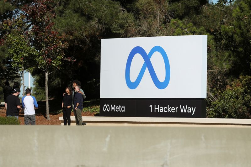 © Reuters. People pose for a photo in front of a sign of Meta, the new name for the company formerly known as Facebook, at its headquarters in Menlo Park, California, U.S. October 28, 2021. REUTERS/Nathan Frandino