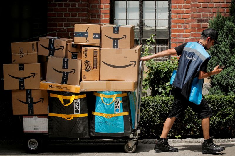 © Reuters. FILE PHOTO: An Amazon delivery worker pulls a delivery cart full of packages during its annual Prime Day promotion in New York City, U.S., June 21, 2021.  REUTERS/Brendan McDermid