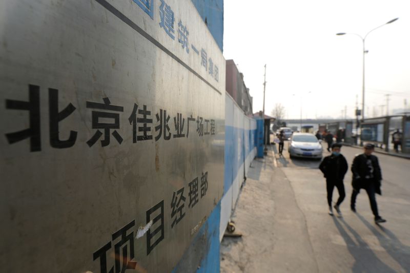 &copy; Reuters. FILE PHOTO: People walk past a construction site of Kaisa Plaza in Beijing, January 13, 2015. REUTERS/Jason lee 