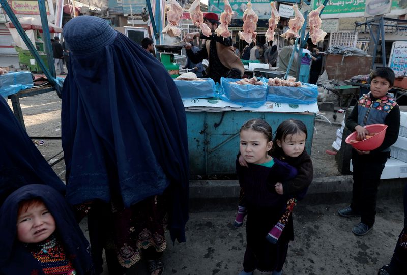 &copy; Reuters. امرأة مع أطفالها داخل سوق بالعاصمة الأفغانية كابول في صورة التقطت يوم الجمعة. تصوير: زهرة بنسمرة - رويترز 