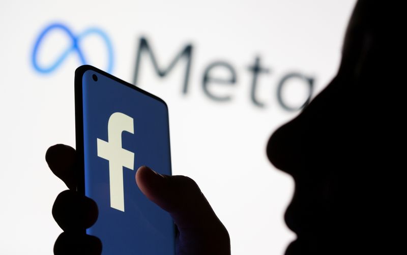 &copy; Reuters. FILE PHOTO: Woman holds smartphone with Facebook logo in front of a displayed Facebook's new rebrand logo Meta in this illustration picture taken October 28, 2021. REUTERS/Dado Ruvic/Illustration