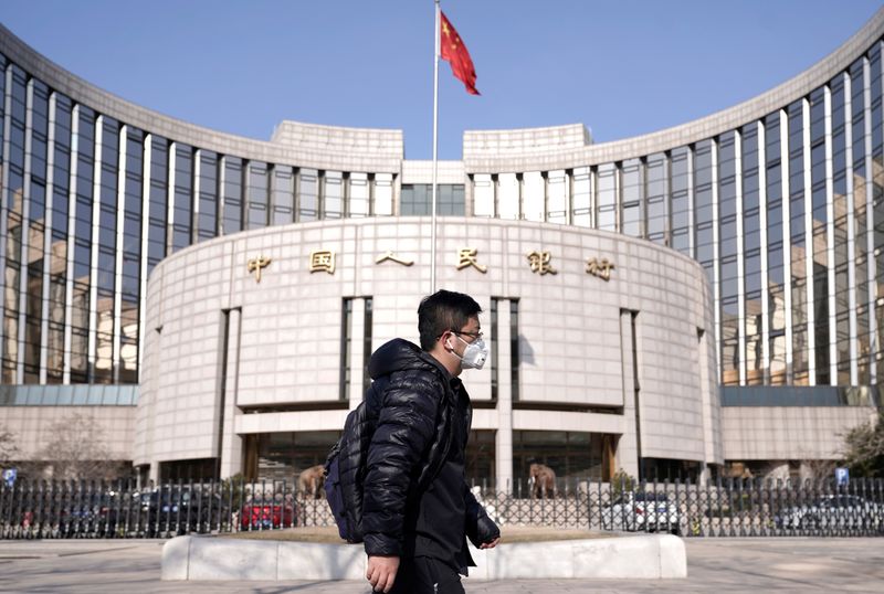 &copy; Reuters. FOTO DE ARCHIVO. Un hombre con una máscara pasa por delante de la sede del Banco Popular de China, el banco central, en Pekín, China. 3 de febrero de 2020. REUTERS/Jason Lee