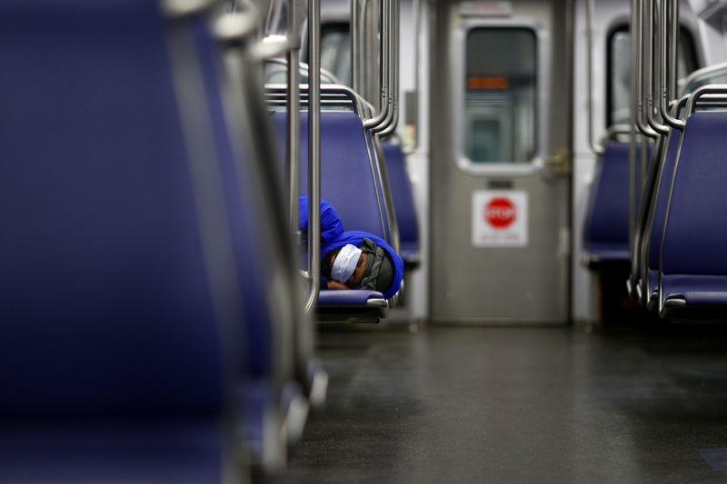 &copy; Reuters. A person rests on a Washington Metro subway car wearing a face mask, following Mayor Muriel Bowser's declaration of a state of emergency due to the coronavirus disease (COVID-19)  in Washington, U.S., April 13, 2020. REUTERS/Tom Brenner     TPX IMAGES OF 