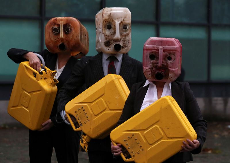 &copy; Reuters. Activistas de Ocean Rebellion utilizan bidones como máscaras durante una protesta ante la sede de la COP26 en Glasgow, Escocia.
