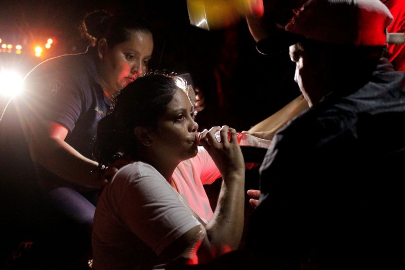 © Reuters. امرأة مهاجرة تشرب أثناء تلقيها المساعدة من قبل ضباط شرطة في الفورتين بالمكسيك يوم الجمعة. تصوير:رويترز.