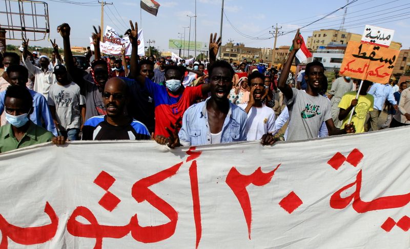 © Reuters. محتجون يرفعون لافتة تحمل شعار مظاهرة كبيرة خرجت يوم السبت ضد انفراد الجيش بالسلطة في السودان. تصوير: محمد نور الدين - رويترز