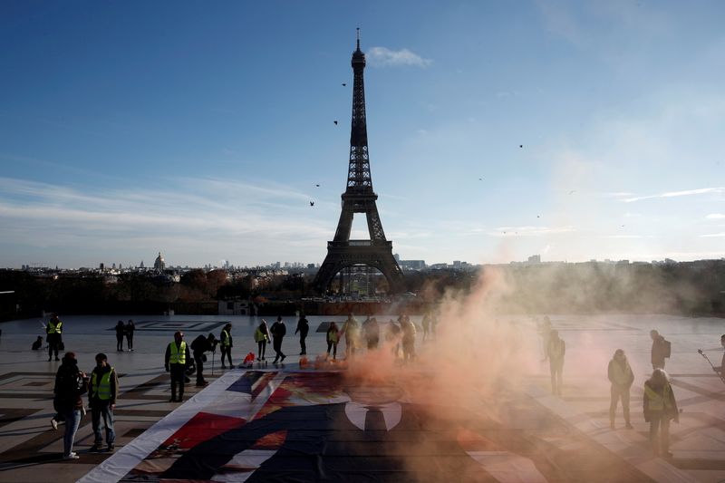 &copy; Reuters. FILE PHOTO: Climate activists stand next to a giant portrait of French President Emmanuel Macron installed on the ground at Trocadero square in front of the Eiffel tower to mark the fifth anniversary of the 2015 United Nations Paris Agreement on climate c