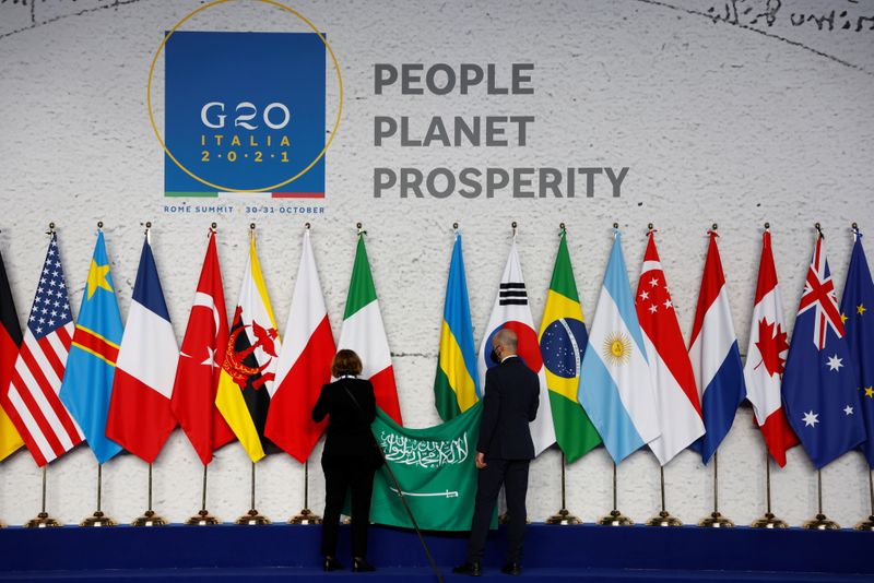 &copy; Reuters. FILE PHOTO: Employees arrange the Saudi Arabian flag during the final preparations before world leaders gather for the official family photograph on day one of the G20 leaders summit at the convention center of La Nuvola, in Rome, October 30, 2021. Ludovi