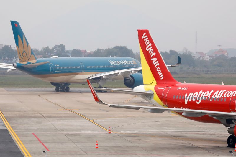 &copy; Reuters. An aircraft of the national flag carrier Vietnam Airlines taxis past a Vietjet aircraft at Noi Bai airport in Hanoi, Vietnam December 23, 2020. Picture taken December 23, 2020. REUTERS/Kham