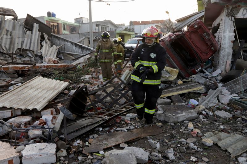 © Reuters. عمال أطفاء يسيرون وسط الانقاض بعد انفجار  في خط أنابيب لشركة بيمكس للنفط في ولاية بويبلا وسط المكسيك يوم الأحد. تصوير:رويترز.