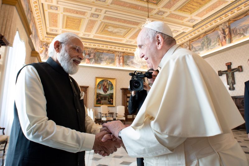 &copy; Reuters. 　ローマ教皇フランシスコ（右）が、インドのモディ首相（左）の訪印招請を受け入れたことが分かった。１０月３０日、バチカンメディアの提供写真（２０２１年　ロイター）