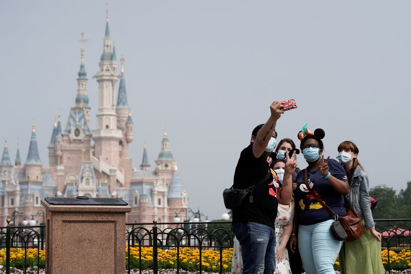 &copy; Reuters. FILE PHOTO: Visitors wearing protective face masks pose for a picture at Shanghai Disney Resort as the Shanghai Disneyland theme park reopens following a shutdown due to the coronavirus disease (COVID-19) outbreak, in Shanghai, China May 11, 2020. REUTERS