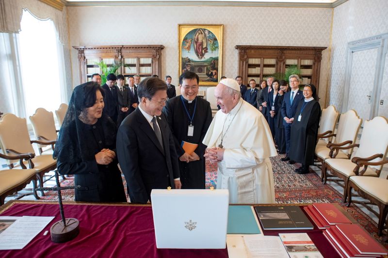 &copy; Reuters.  １０月２９日、韓国の文在寅（ムン・ジェイン）大統領（写真中央）は、ローマ教皇フランシスコ（同右に謁見した。バチカン提供（２０２１年　ロイター）