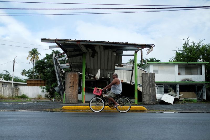 &copy; Reuters. FILE PHOTO: A man rides his bicycle past a gas station that was damaged by Hurricane Maria two years ago, as Tropical Storm Karen approaches in Loiza, Puerto Rico September 24, 2019.  REUTERS/Ricardo Arduengo